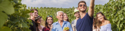 group of tourists take a selfie outdoor in the vineyard during a lesson about growing wine